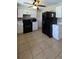 Well-lit kitchen featuring white cabinetry, black appliances, and neutral tile flooring at 7813 Arabian Pl, Orlando, FL 32818