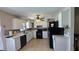 Bright kitchen featuring white cabinets, black appliances, and a ceiling fan at 7813 Arabian Pl, Orlando, FL 32818