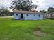 House and backyard overgrown with tall grass, needing cleanup and improvements, offers a great space for outdoor activities at 838 Bethune Ave, Winter Garden, FL 34787