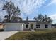 Newly constructed ranch home with an attached two car garage and neutral colored exterior paint at 95 Water Trak, Ocala, FL 34472