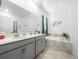 Bright bathroom featuring double sinks, gray cabinets, and a separate tub, offering a luxurious spa-like experience at 9747 Petition Way, Orlando, FL 32832