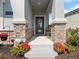 Inviting front porch with stone accents and colorful floral arrangements at 9747 Petition Way, Orlando, FL 32832