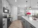 Well-lit kitchen with white countertops, gray cabinetry and stainless appliances at 9747 Petition Way, Orlando, FL 32832