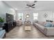 Bright living room featuring stylish furniture, a ceiling fan, and large windows providing ample natural light at 9747 Petition Way, Orlando, FL 32832
