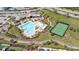 An aerial view showcasing a resort-style community pool, playground, and tennis court at 9747 Petition Way, Orlando, FL 32832