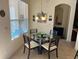 Bright dining area with a glass table and modern lighting next to a large window at 4847 Lake Milly Dr, Orlando, FL 32839