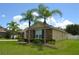 Charming single-story home featuring stone accents, well-manicured lawn and mature palm trees on a sunny day at 4847 Lake Milly Dr, Orlando, FL 32839
