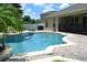 Inviting backyard pool with a stone waterfall feature and lush landscaping at 4847 Lake Milly Dr, Orlando, FL 32839