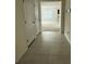 Hallway featuring tile floors, closet doors, and an entrance to the carpeted living room at 124 Sofia Ln, Lake Alfred, FL 33850