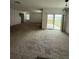 Spacious living room with neutral carpet, a ceiling fan, and sliding glass doors to the backyard at 124 Sofia Ln, Lake Alfred, FL 33850