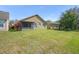 Expansive backyard with lush green grass, mature trees, and a view of the rear of the home at 12824 Penshurst Ln, Windermere, FL 34786