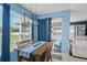 Dining area features wood table and seating with a modern lighting fixture and backyard view at 12824 Penshurst Ln, Windermere, FL 34786