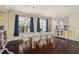 This dining room features a modern chandelier, large windows with drapes, and unique wall art at 12824 Penshurst Ln, Windermere, FL 34786