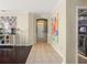 Hallway showing transition from tiled area to hardwood floors, laundry and front door at 12824 Penshurst Ln, Windermere, FL 34786