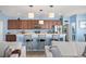 Modern kitchen features wooden cabinets, stainless appliances, counter seating and views to the living room at 12824 Penshurst Ln, Windermere, FL 34786
