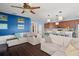 Bright living room with couches, dark wood floors and kitchen with stainless steel appliances at 12824 Penshurst Ln, Windermere, FL 34786