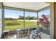 Relaxing screened patio offering views of a lush, green backyard and tranquil pond at 12824 Penshurst Ln, Windermere, FL 34786
