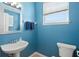 Well-lit powder room with pedestal sink, a window for natural light and tile flooring at 12824 Penshurst Ln, Windermere, FL 34786