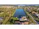 Aerial view of luxury home with well-manicured yard, pool, and circular driveway, nestled next to a scenic lake at 13305 Bellaria Cir, Windermere, FL 34786
