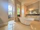 A luxurious bathroom featuring a standalone tub, arched windows, and elegant tile work at 13305 Bellaria Cir, Windermere, FL 34786