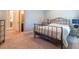 Cozy bedroom featuring neutral carpet, iron bed frame, and ensuite bathroom access at 13305 Bellaria Cir, Windermere, FL 34786