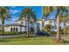 Elegant white home with arched windows, a tile roof, and a beautifully manicured lawn with a black luxury car at 13305 Bellaria Cir, Windermere, FL 34786