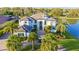 Stunning luxury home featuring a tile roof, manicured landscaping, and a circular driveway, set beside a tranquil lake at 13305 Bellaria Cir, Windermere, FL 34786
