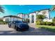 Beautifully landscaped home with lush greenery, arched windows and a black luxury car parked on the paved driveway at 13305 Bellaria Cir, Windermere, FL 34786
