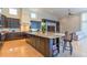 Gourmet kitchen featuring a large island with granite countertops and dark wood cabinets, flowing into the living area at 13305 Bellaria Cir, Windermere, FL 34786