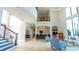 Bright and spacious living room with large windows, travertine floors, staircase, and a second floor balcony at 13305 Bellaria Cir, Windermere, FL 34786