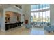 Bright living room with soaring ceilings, a wall of windows, and a comfortable seating area with bar and counter seating at 13305 Bellaria Cir, Windermere, FL 34786