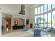 Bright living room with soaring ceilings, a wall of windows, and a comfortable seating area with bar and counter seating at 13305 Bellaria Cir, Windermere, FL 34786