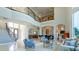 Open-concept living room with large windows, travertine floors, staircase, and second floor balcony at 13305 Bellaria Cir, Windermere, FL 34786