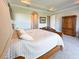 Bright main bedroom featuring a tray ceiling, an ensuite bathroom entrance, and hardwood furniture at 13305 Bellaria Cir, Windermere, FL 34786