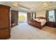 Spacious main bedroom featuring tray ceiling, balcony access, and classic wood furniture at 13305 Bellaria Cir, Windermere, FL 34786