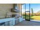 Close up of the outdoor kitchen, featuring a stainless steel grill, vent hood, and granite countertop at 13305 Bellaria Cir, Windermere, FL 34786