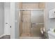 Shower with neutral-toned tiles, glass door, and convenient shelving at 1375 Tuscana Ln # 1406, Davenport, FL 33896