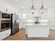Bright kitchen with white cabinetry, stainless steel appliances, a central island, and modern pendant lighting at 15543 Gentle Rain Dr # 197, Winter Garden, FL 34787