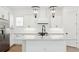 Modern kitchen featuring white cabinets, stainless steel appliances, a large island, and designer light fixtures at 15543 Gentle Rain Dr # 197, Winter Garden, FL 34787