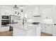 Well-equipped kitchen with stainless appliances, white cabinets, a center island, and stylish pendant lights at 15543 Gentle Rain Dr # 197, Winter Garden, FL 34787