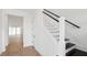Bright interior with a staircase featuring white railings, dark steps, and wooden floors in the entryway at 15543 Gentle Rain Dr # 197, Winter Garden, FL 34787