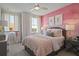 Charming bedroom with pink accents, soft textures, and natural light at 15567 Gentle Rain Dr # 194, Winter Garden, FL 34787
