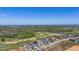 An aerial view captures modern homes adjacent to a golf course and waterfront landscape at 15847 Vetta Dr, Bella Collina, FL 34756