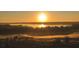 Sunrise view of a beautiful golf course community located next to a lake at 15847 Vetta Dr, Bella Collina, FL 34756