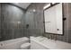 Modern bathroom featuring sleek gray tiling, a white vanity, and stylish fixtures at 15847 Vetta Dr, Bella Collina, FL 34756