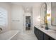 Bright bathroom featuring double vanity, soaking tub, and walk-in closet for ample storage space at 15847 Vetta Dr, Bella Collina, FL 34756