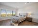 Bright bedroom featuring a tufted headboard, bench, wood floors, and plantation shutters with a scenic view at 15847 Vetta Dr, Bella Collina, FL 34756
