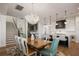 Bright dining area with modern light fixture, wooden table, and seamless transition into a modern kitchen at 15847 Vetta Dr, Bella Collina, FL 34756
