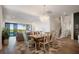 Elegant dining area with a modern chandelier, hardwood floors, and a view of the outdoor pool at 15847 Vetta Dr, Bella Collina, FL 34756