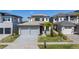 Daytime view of a modern two-story home with a well-kept lawn, stone accents, and a two-car garage at 15847 Vetta Dr, Bella Collina, FL 34756
